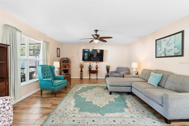 living room featuring ceiling fan and baseboards