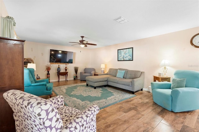 living room featuring baseboards, visible vents, and a ceiling fan