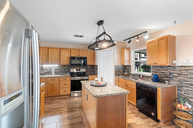 kitchen with tasteful backsplash, visible vents, a center island, black appliances, and a sink