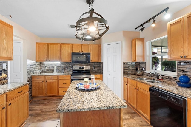 kitchen with black appliances, tasteful backsplash, a sink, and light stone countertops