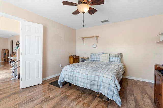 bedroom featuring light wood-type flooring, baseboards, visible vents, and a ceiling fan