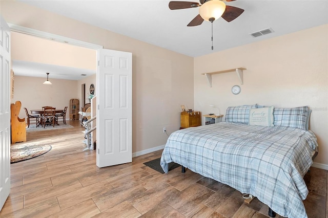 bedroom with baseboards, ceiling fan, visible vents, and wood tiled floor