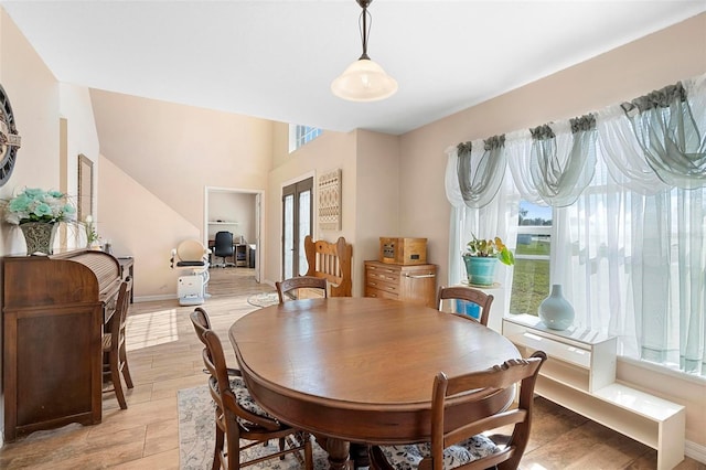 dining space featuring light wood finished floors and baseboards