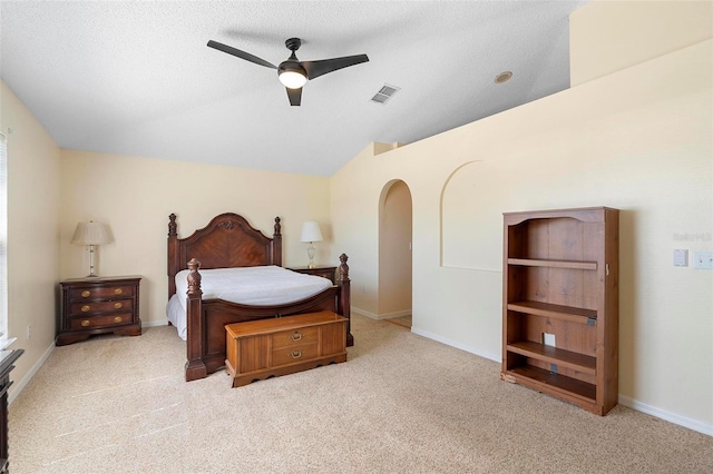 carpeted bedroom with lofted ceiling, baseboards, visible vents, and arched walkways