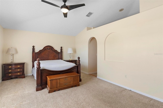 carpeted bedroom featuring baseboards, visible vents, arched walkways, ceiling fan, and vaulted ceiling