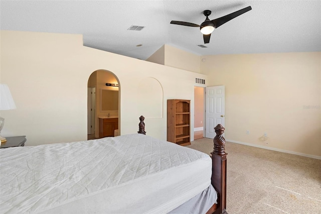 carpeted bedroom featuring arched walkways, visible vents, vaulted ceiling, and baseboards