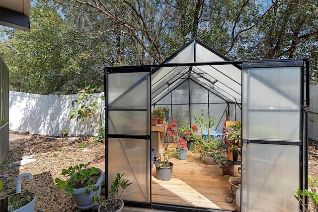 view of greenhouse featuring fence