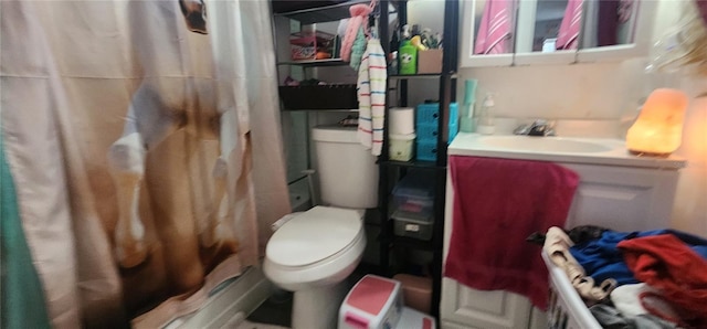 bathroom featuring toilet, a shower with shower curtain, and vanity