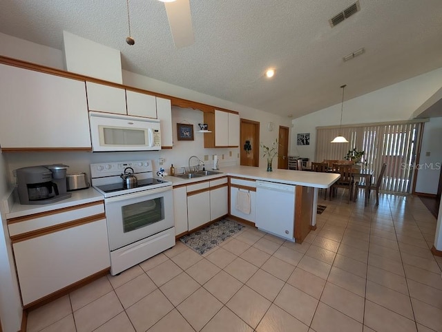 kitchen featuring light countertops, visible vents, a sink, white appliances, and a peninsula