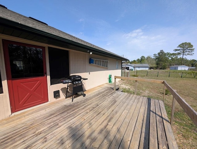 wooden deck featuring a lawn, area for grilling, and fence