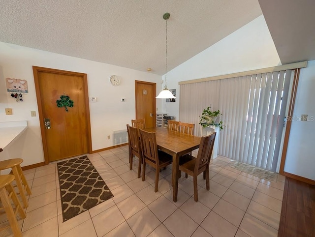 dining space featuring light tile patterned floors, visible vents, vaulted ceiling, and a textured ceiling