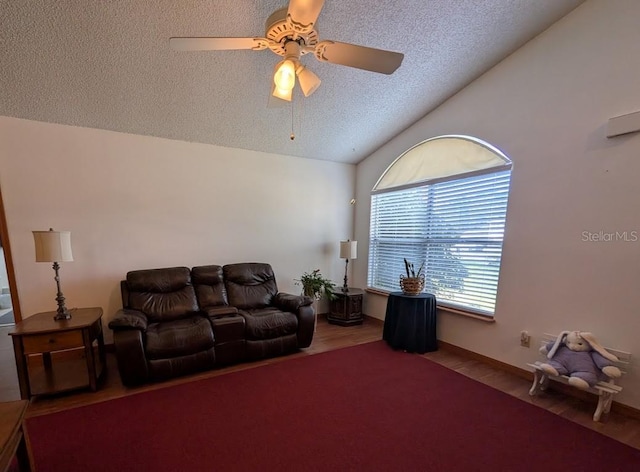 living area featuring a textured ceiling, a ceiling fan, vaulted ceiling, and wood finished floors