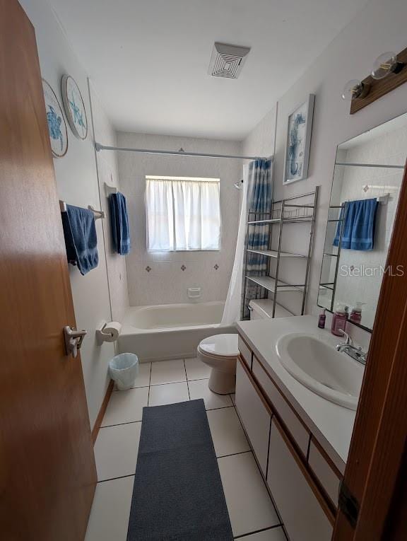 bathroom with toilet, vanity, visible vents, tile patterned floors, and shower / bath combo