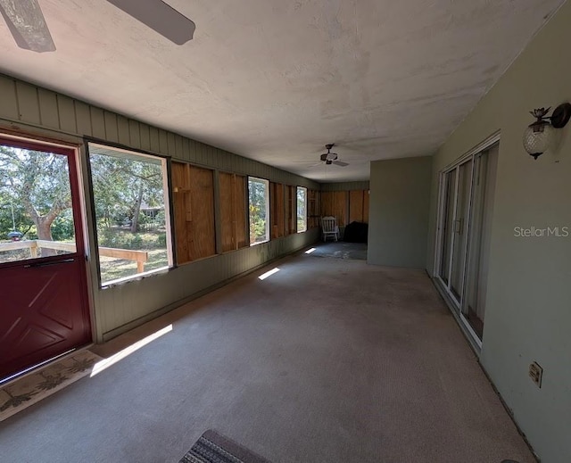 unfurnished sunroom with a ceiling fan