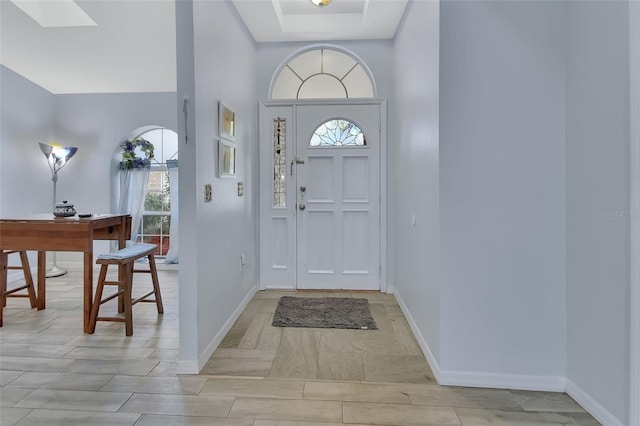 foyer featuring a skylight and baseboards