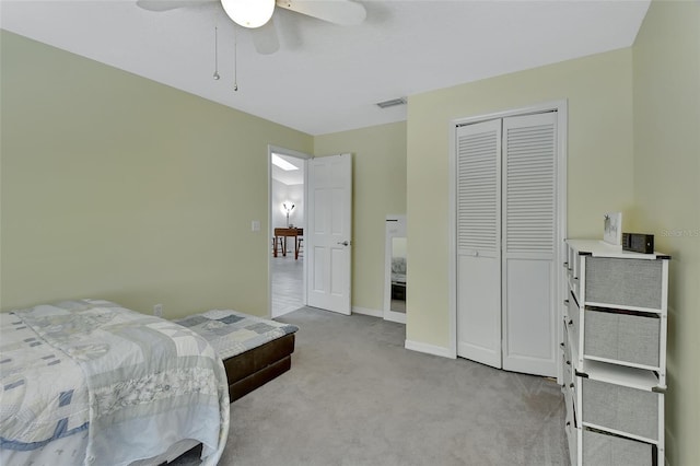 bedroom with light carpet, baseboards, visible vents, ceiling fan, and a closet