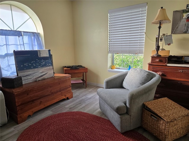 living area with baseboards and wood finished floors