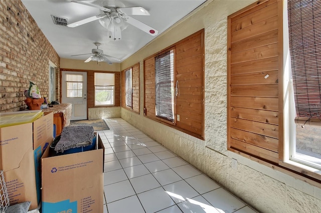 sunroom featuring a ceiling fan and visible vents