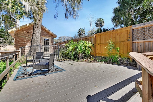 wooden deck featuring an outbuilding and a fenced backyard