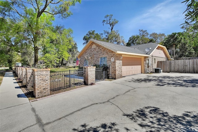 view of side of home with a garage, brick siding, fence, and aphalt driveway