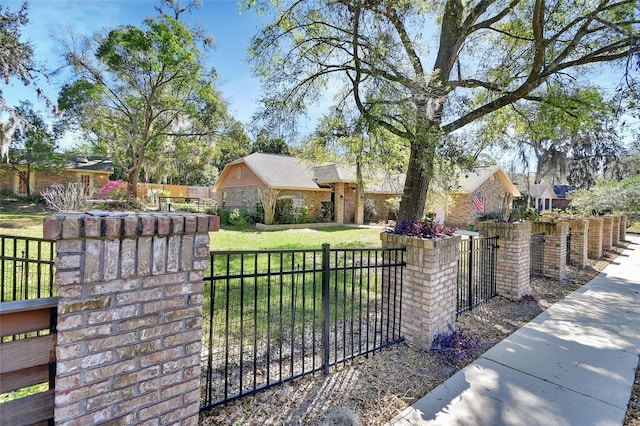 view of gate with a fenced front yard and a yard