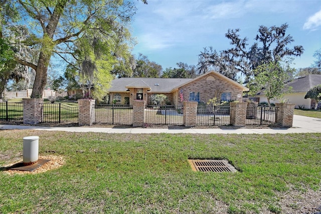 ranch-style home featuring a fenced front yard, a front yard, and brick siding