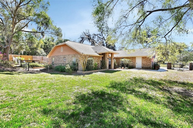 view of front of home featuring fence, a front lawn, and brick siding