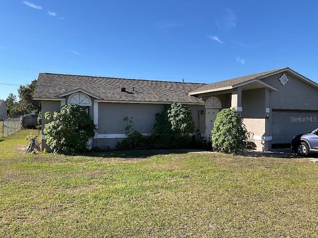 ranch-style home with a garage, fence, a front lawn, and stucco siding