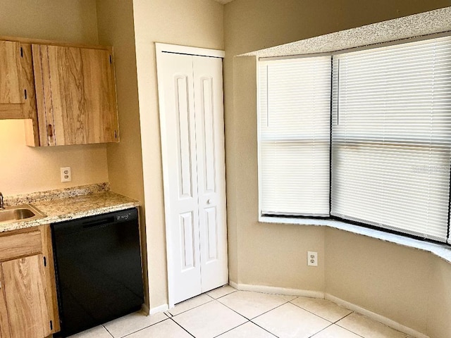 kitchen featuring light tile patterned floors, a sink, black dishwasher, baseboards, and light countertops