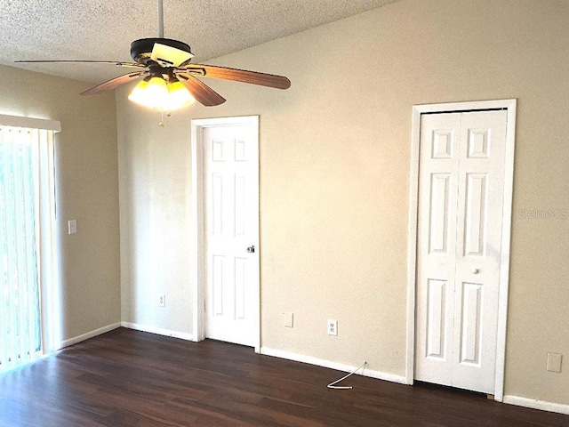 unfurnished bedroom with dark wood-style flooring, baseboards, and a ceiling fan
