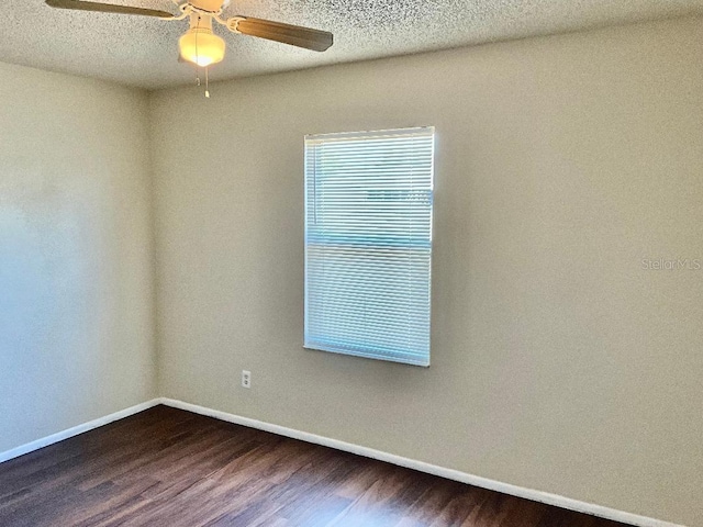 unfurnished room featuring baseboards, ceiling fan, a textured ceiling, and wood finished floors