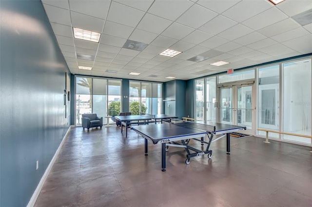 recreation room featuring a wall of windows, visible vents, baseboards, french doors, and a paneled ceiling