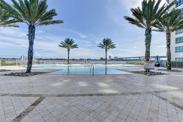 community pool with a patio and fence