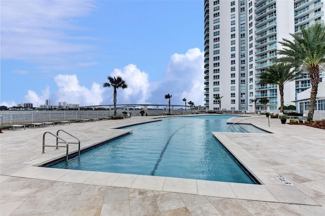 community pool with a patio area and a view of city