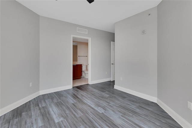 spare room with visible vents, baseboards, and wood finished floors