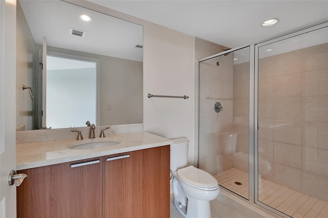 bathroom featuring visible vents, toilet, a stall shower, and vanity