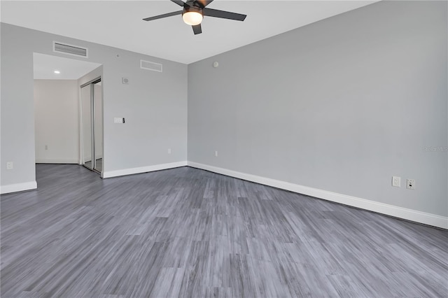 unfurnished room featuring visible vents, ceiling fan, baseboards, and wood finished floors