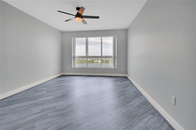 empty room with ceiling fan, baseboards, and wood finished floors