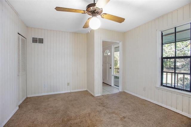 unfurnished bedroom with visible vents, carpet floors, baseboards, and a ceiling fan