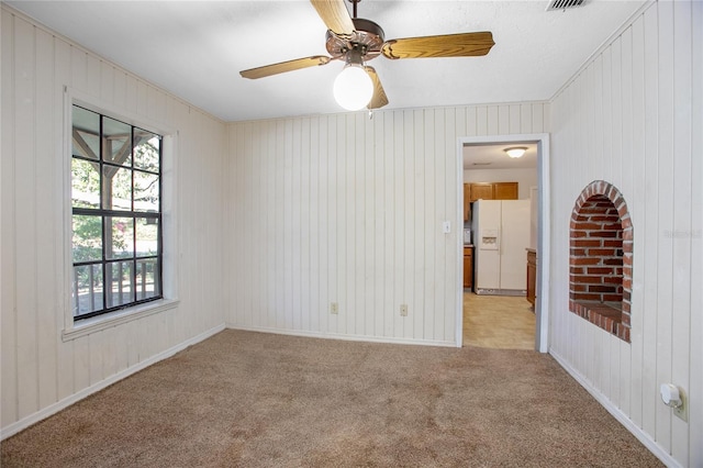 unfurnished room featuring baseboards, light colored carpet, and a ceiling fan