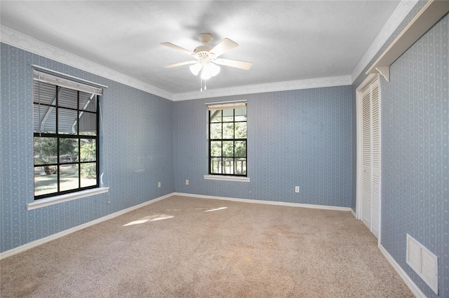 unfurnished room featuring a ceiling fan, visible vents, baseboards, wallpapered walls, and carpet flooring