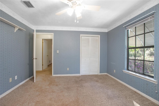 unfurnished bedroom featuring visible vents, baseboards, carpet, and wallpapered walls