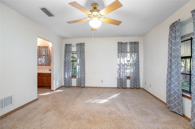 spare room featuring baseboards, visible vents, and carpet floors