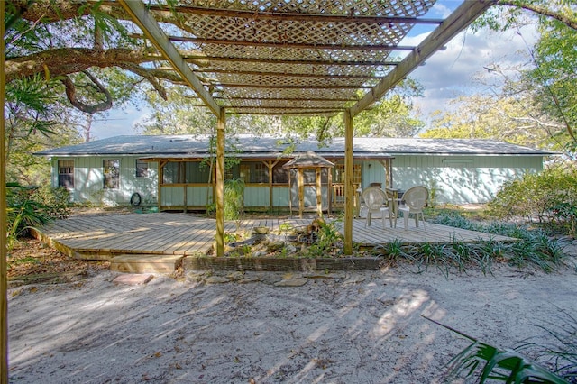 rear view of property featuring a wooden deck and a pergola