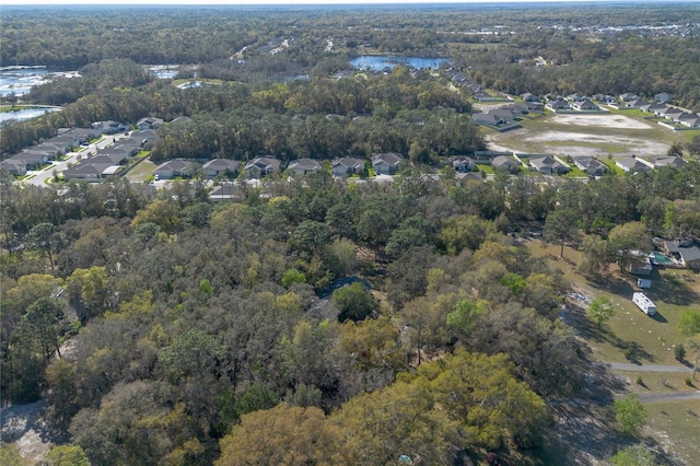 birds eye view of property featuring a residential view, a wooded view, and a water view