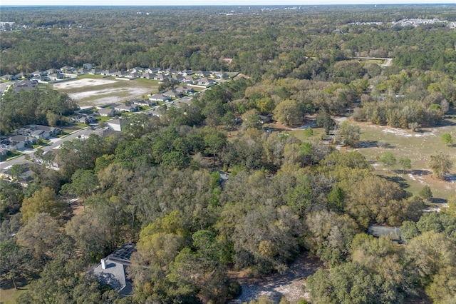 bird's eye view with a wooded view