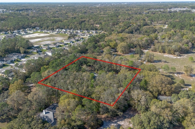 birds eye view of property featuring a wooded view