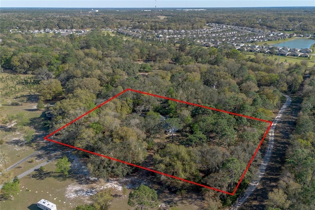 drone / aerial view with a forest view and a water view