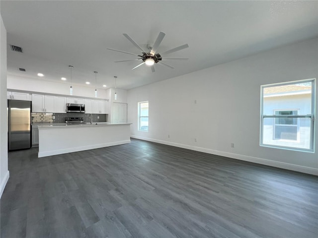 unfurnished living room featuring a ceiling fan, visible vents, baseboards, recessed lighting, and dark wood-style flooring