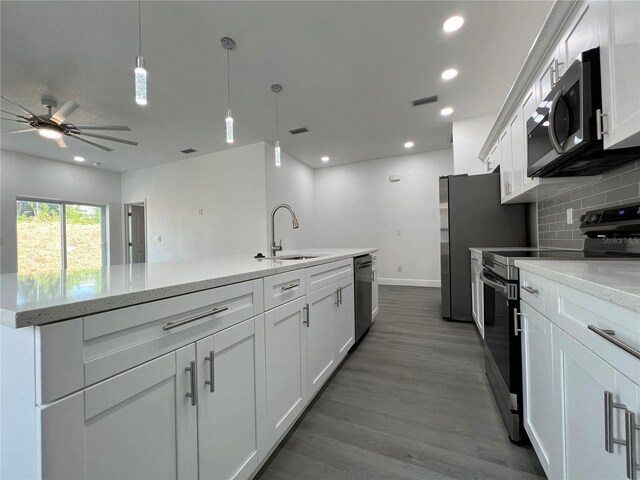 kitchen with visible vents, backsplash, appliances with stainless steel finishes, wood finished floors, and a sink